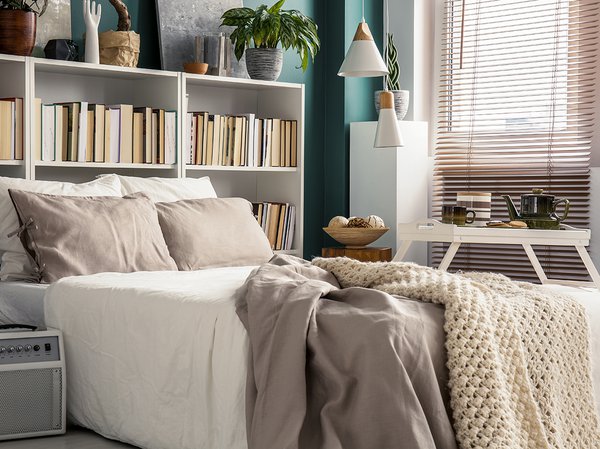 Creative use of small space in a stylish bedroom interior with designer decor and cozy white and beige bedding